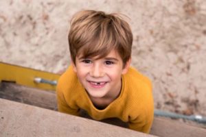 Junge klettert Leiter am Spielplatz hoch während Kitafotografin von oben fotografiert